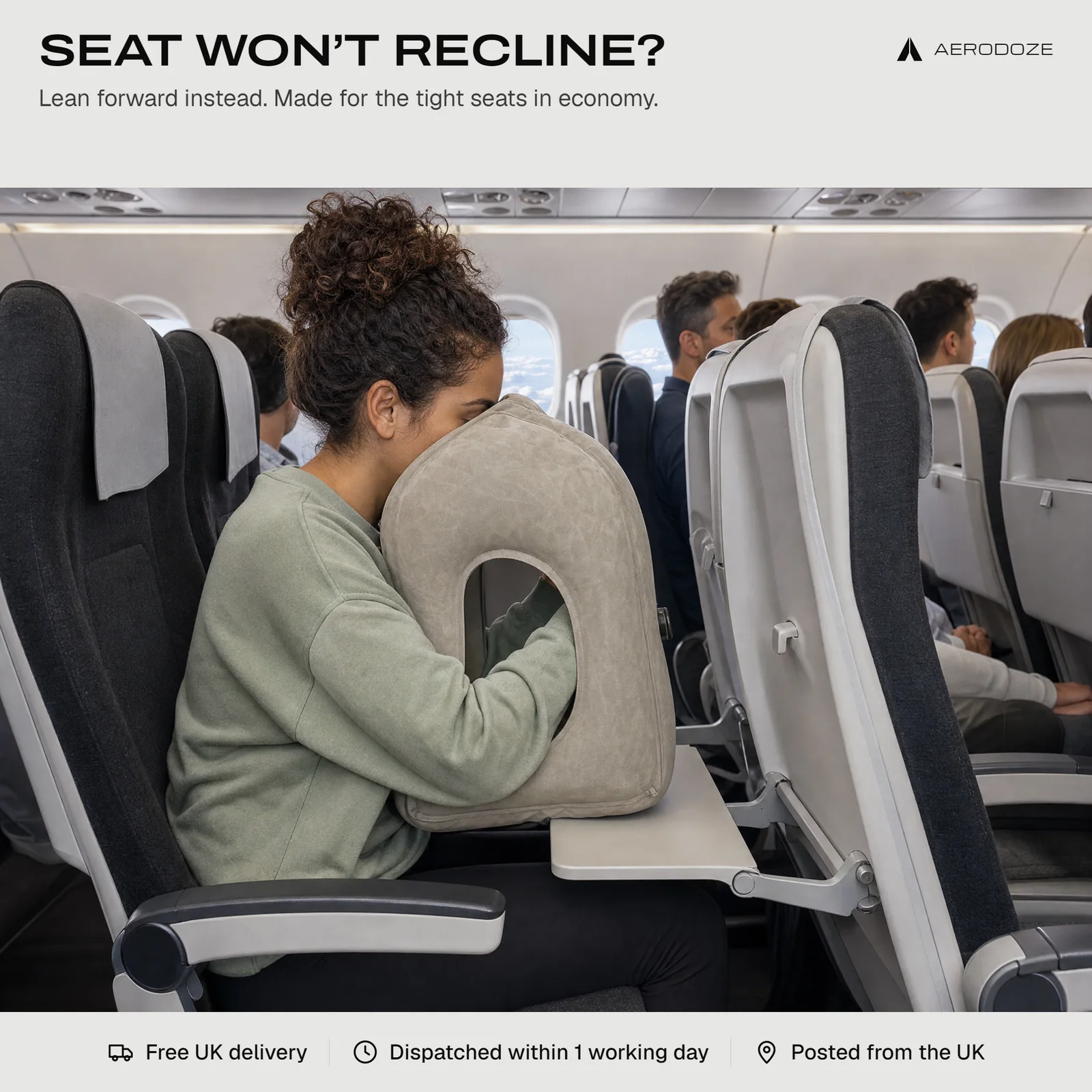Seat won't recline? Lean forward instead. A woman in an economy seat leans forward onto the pillow on her tray table, face in the cradle and arms through the sides.